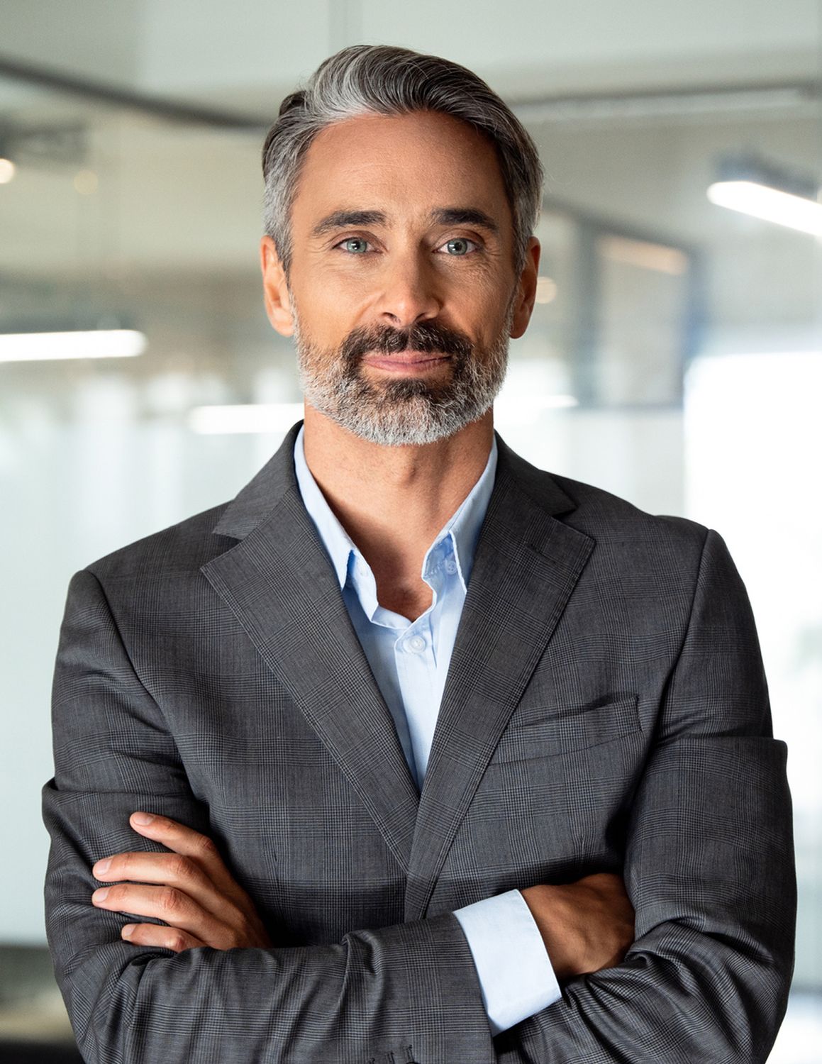 Confident man in a suit with folded arms.